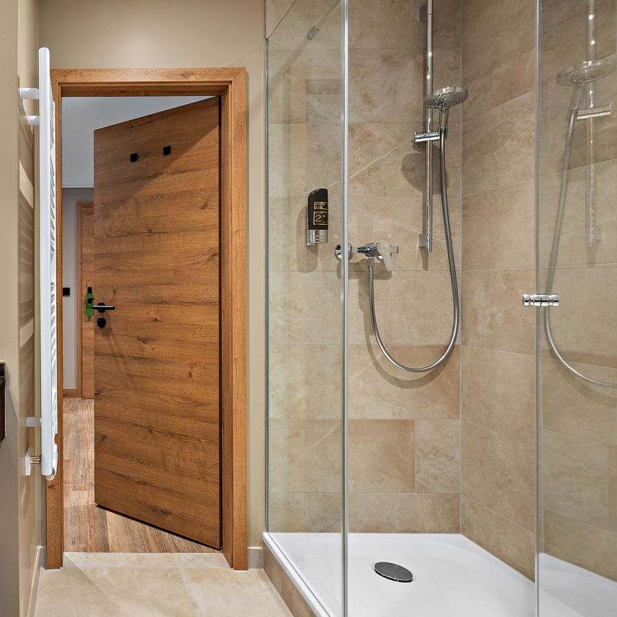 Badezimmer im Prinzess-Zimmer des Wellnesshotels Churfürstenhof mit Waschtisch, rundem Spiegel und Glasdusche