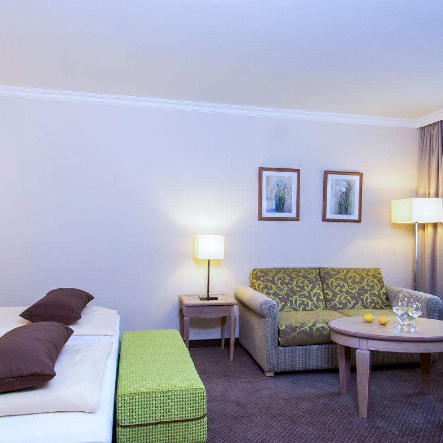 Hotelzimmer Baroness im Churfürstenhof Bad Birnbach mit Doppelbett, Sofa und grünen Farbakzenten