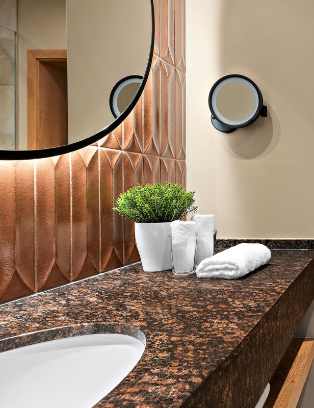 Badezimmer im Prinzess-Zimmer des Wellnesshotels Churfürstenhof mit Waschtisch, rundem Spiegel und Glasdusche