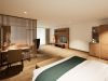 Wohnbereich der Junior Suite im Hotel Churfürstenhof mit Schreibtisch, Holzlamellenwand und TV-Board