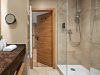Badezimmer im Prinzess-Zimmer des Wellnesshotels Churfürstenhof mit Waschtisch, rundem Spiegel und Glasdusche