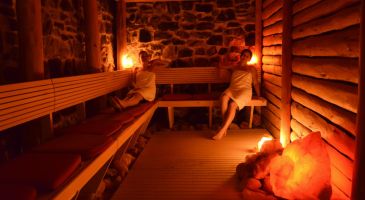Zwei Frauen entspannen in der rustikalen Steinsauna mit leuchtenden Salzkristallen im Hotel Churfürstenhof