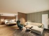 Wohnbereich der Junior Suite mit Ecksofa, Sessel und Doppelbett im Hotel Churfürstenhof