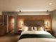 Junior Suite im Hotel Churfürstenhof: Doppelbett vor Holz-Kopfteil mit Pendelleuchten (Visualisierung)