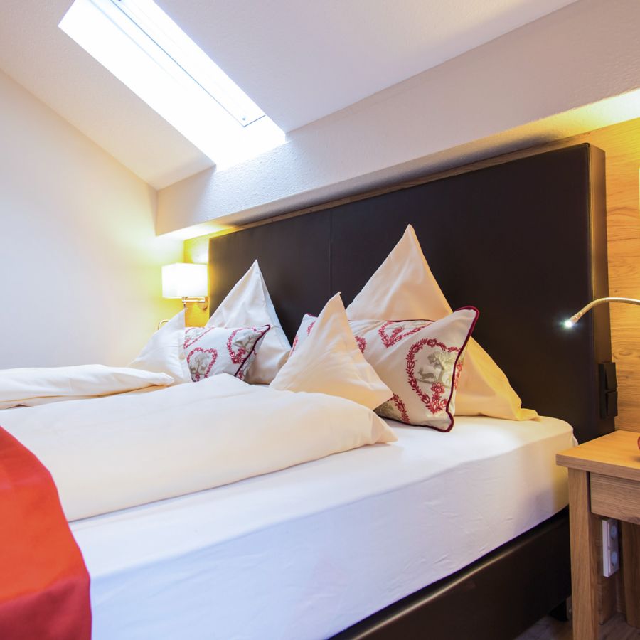 Doppelbett unter Dachschräge mit Dachfenster im Bad Birnbacher Chalet, Hotel Churfürstenhof Bad Birnbach