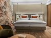 Hotelzimmer Prinzess im Wellnesshotel Churfürstenhof: Doppelbett, grüner Ohrensessel und florales Wandbild