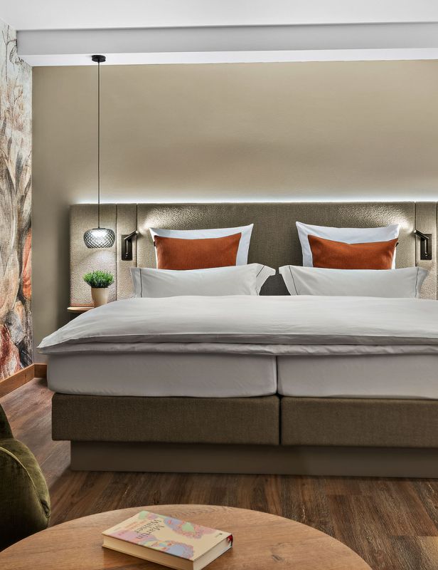 Hotelzimmer Prinzess im Wellnesshotel Churfürstenhof: Doppelbett, grüner Ohrensessel und florales Wandbild