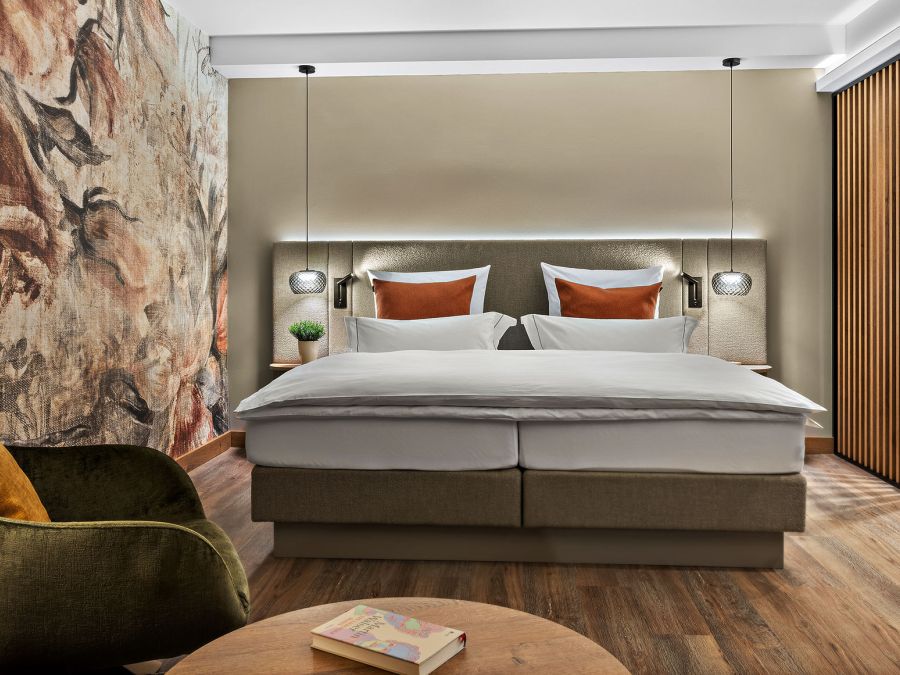 Hotelzimmer Prinzess im Wellnesshotel Churfürstenhof: Doppelbett, grüner Ohrensessel und florales Wandbild