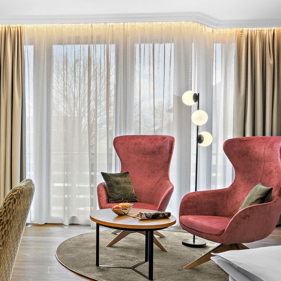 Zimmer Komtess mit zwei roten Sesseln, Schreibtisch und TV im Wellnesshotel Churfürstenhof Bad Birnbach