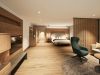Junior Suite mit Doppelbett, grünem Ohrensessel und heller Holzverkleidung im Hotel Churfürstenhof