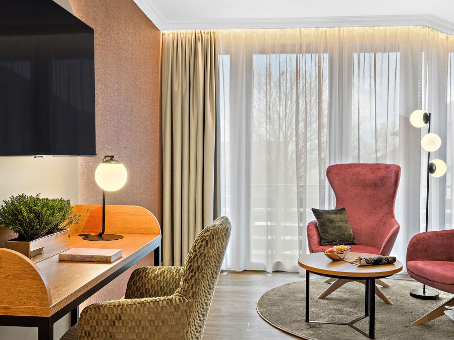 Zimmer Komtess mit zwei roten Sesseln, Schreibtisch und TV im Wellnesshotel Churfürstenhof Bad Birnbach