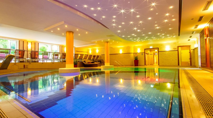 Indoorpool mit beleuchteter Sternenhimmel-Decke und Liegebereich im Hotel Churfürstenhof