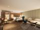 Junior Suite im Hotel Churfürstenhof mit Doppelbett, Ecksofa und Sessel in warmen Naturtönen