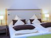 Doppelbett mit heller Bettwäsche und Nachttischlampen im Zimmer Baroness, Hotel Churfürstenhof Bad Birnbach