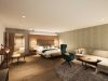 Junior Suite im Hotel Churfürstenhof mit Doppelbett, Ecksofa und Sessel in warmen Naturtönen