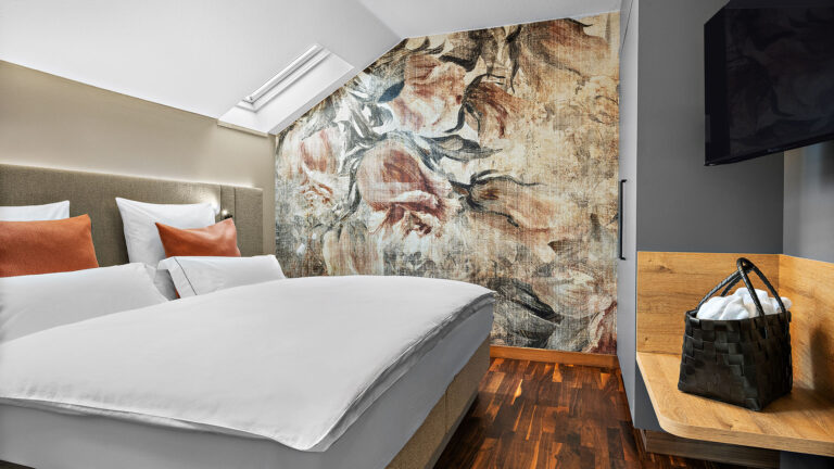Komfort-Suite mit Doppelbett, floralem Wandbild und Parkettboden im Wellnesshotel Churfürstenhof Bad Birnbach