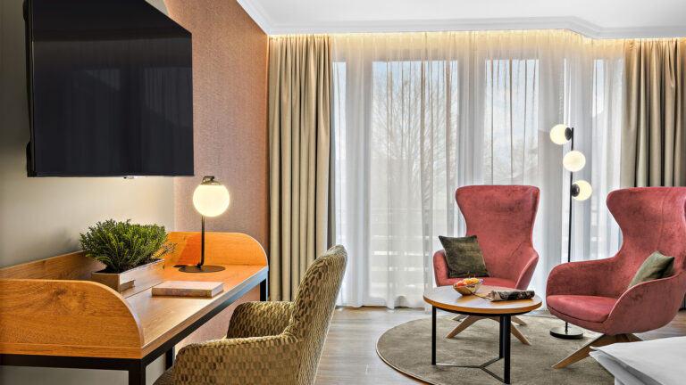 Zimmer Komtess mit zwei roten Sesseln, Schreibtisch und TV im Wellnesshotel Churfürstenhof Bad Birnbach