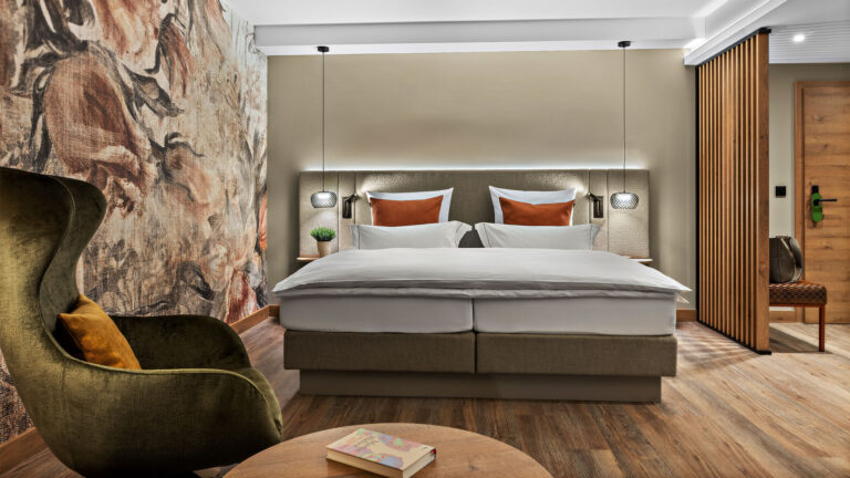 Hotelzimmer Prinzess im Wellnesshotel Churfürstenhof: Doppelbett, grüner Ohrensessel und florales Wandbild