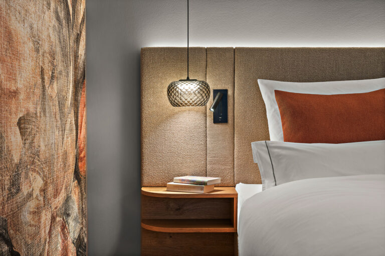 Zimmer Prinzess im Wellnesshotel Churfürstenhof: Bett mit stoffbezogenem Kopfteil, Pendelleuchte und Nachtablage
