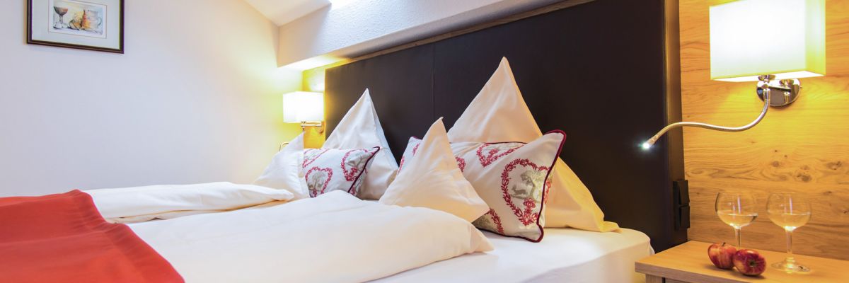 Doppelbett unter Dachschräge mit Dachfenster im Bad Birnbacher Chalet, Hotel Churfürstenhof Bad Birnbach