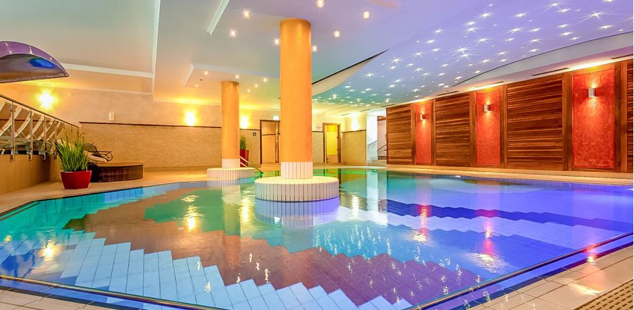 Paar entspannt im Indoorpool mit Sternenhimmel-Beleuchtung im Hotel Churfürstenhof